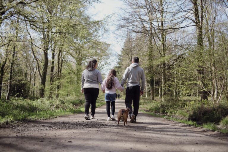 Familie går med hund på en sti i skoven